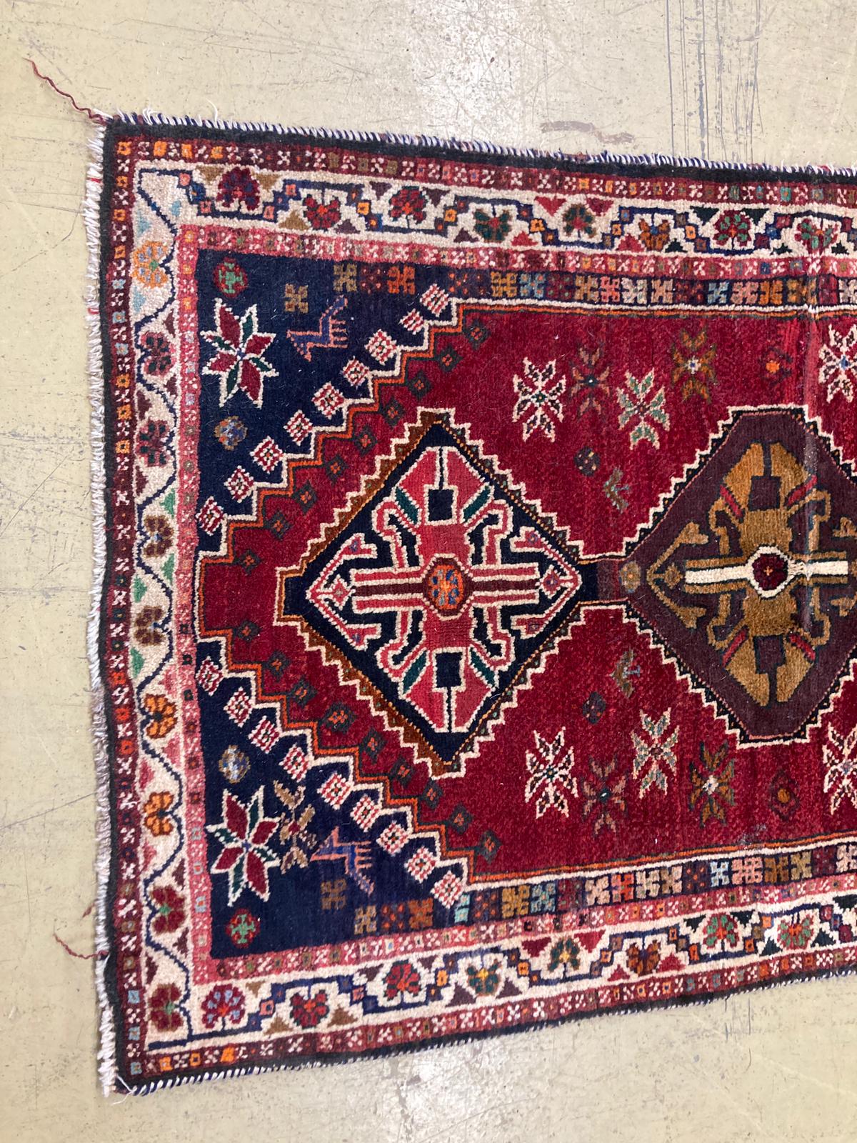 A small Kasak rug with three medallions on a crimson ground, 148 x 95cm
